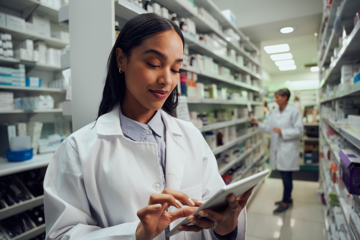 female pharmacist checking inventory on a tablet device