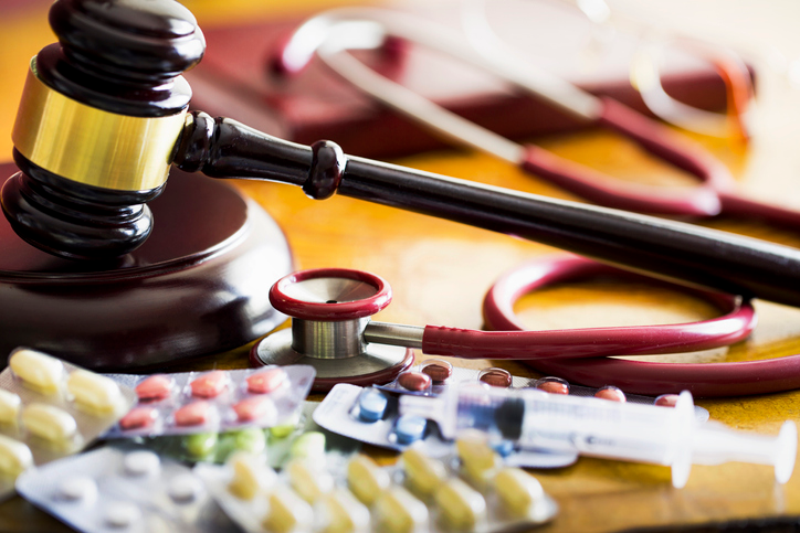 judges gavel with stethoscope and pills