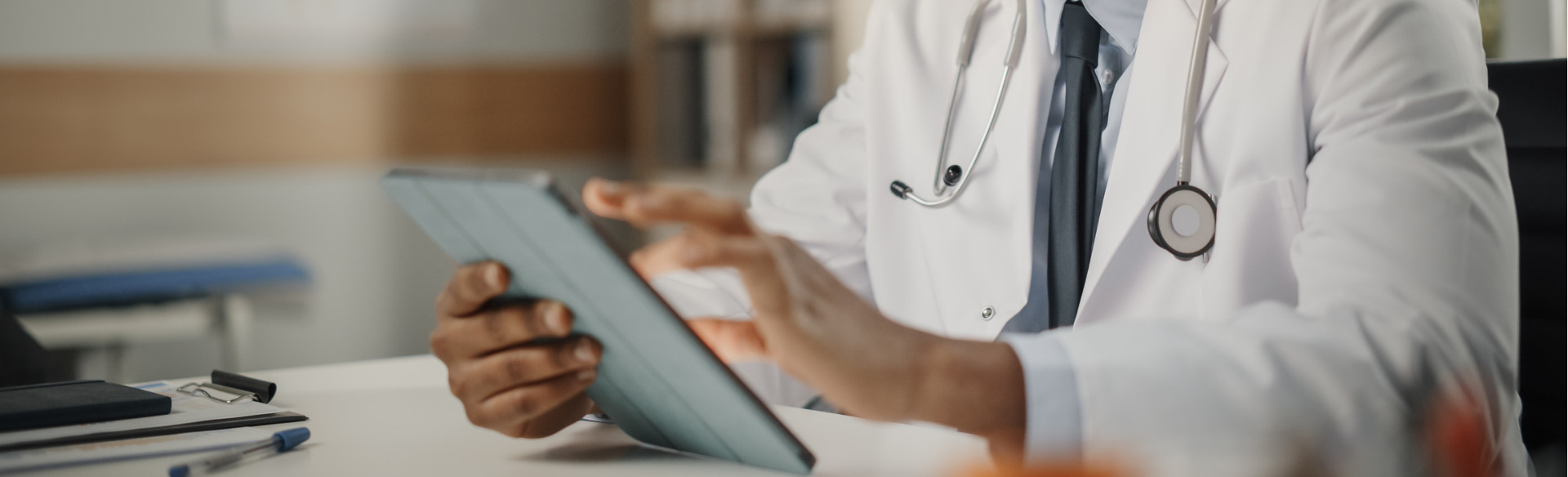 doctor sitting at his desk and working on a tablet device