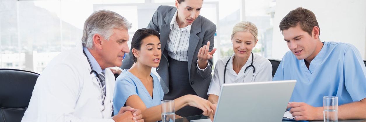 healthcare workers gathered around laptop